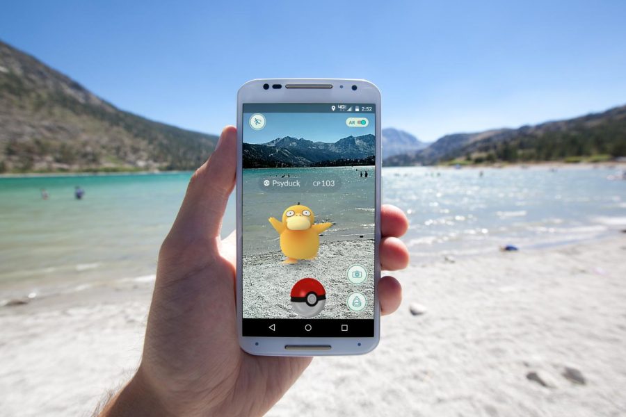 Pokémon Go gamer on the beach using a phone to play