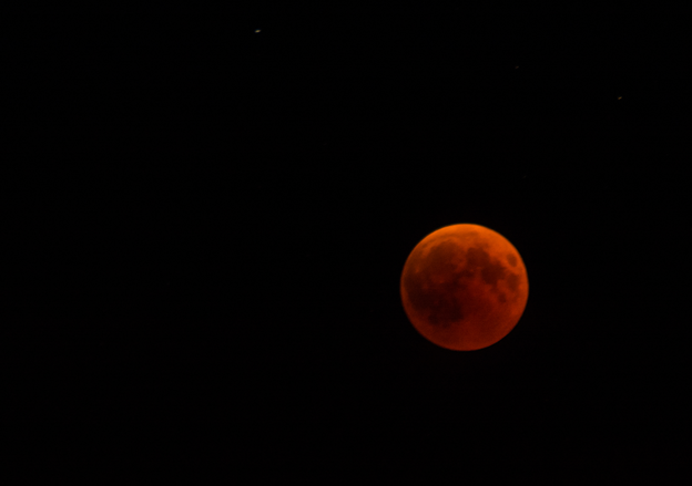 Picture of a red colored Full Moon in a dark sky background