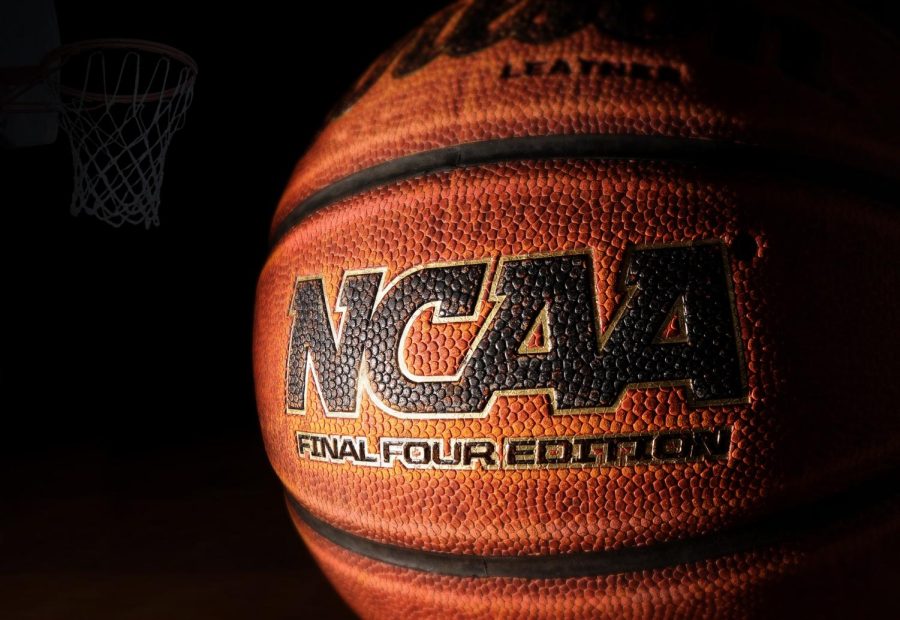 An NCAA Final Four edition basketball rests on hardwood with a hoop in the background.