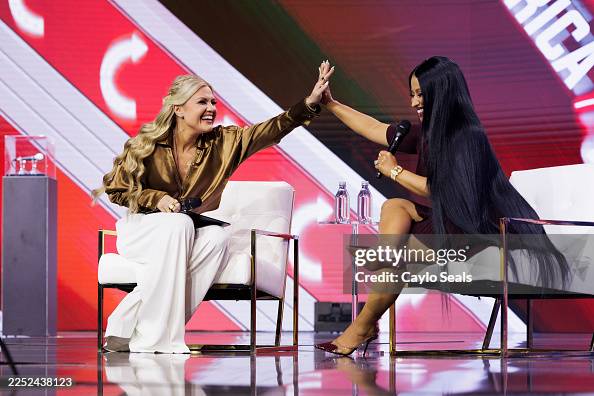 Nicki Minaj high-fiving Erika Kirk during Turning point USA Event.