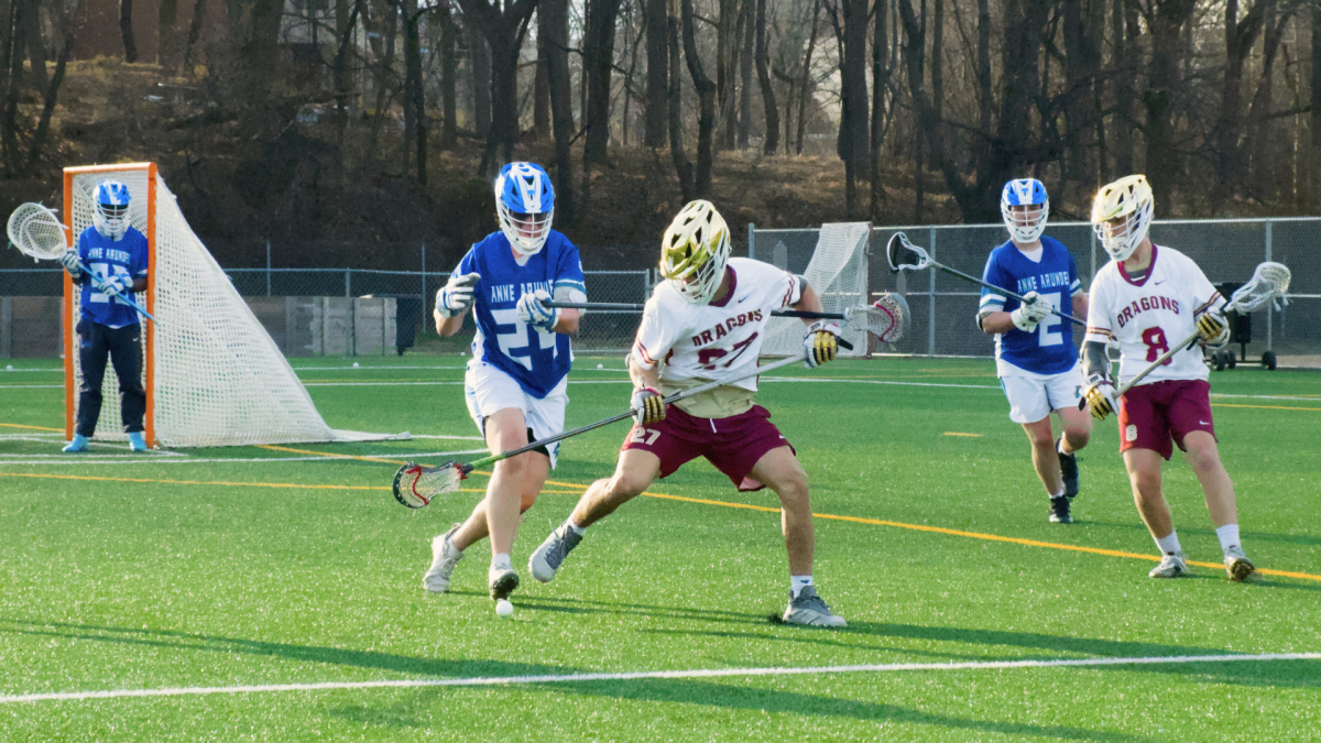 HCC's men's lacrosse team playing during game.