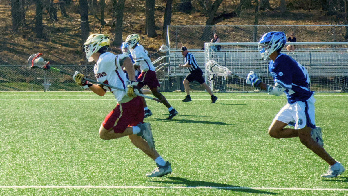 HCC's men's lacrosse team playing during game.