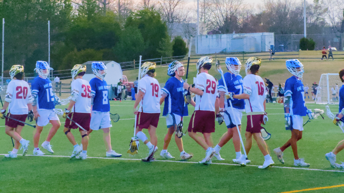 HCC's men's lacrosse team playing during game.
